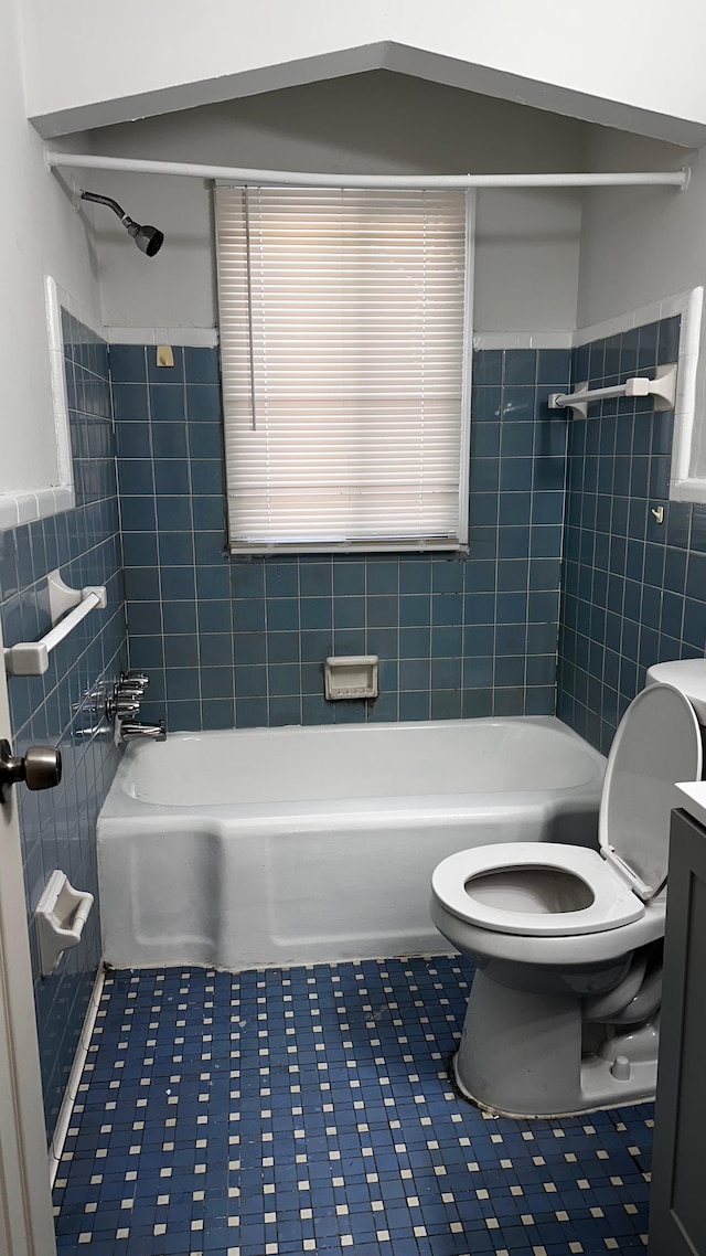 full bathroom with vanity, tiled shower / bath combo, tile patterned flooring, and tile walls