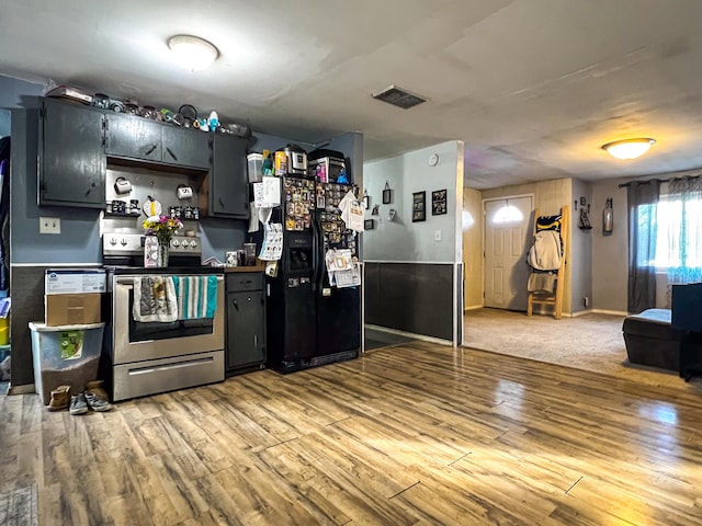 kitchen featuring black fridge with ice dispenser, electric range, and light hardwood / wood-style floors