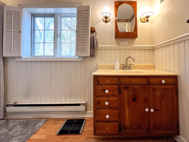 bathroom with a baseboard heating unit, vanity, and hardwood / wood-style flooring