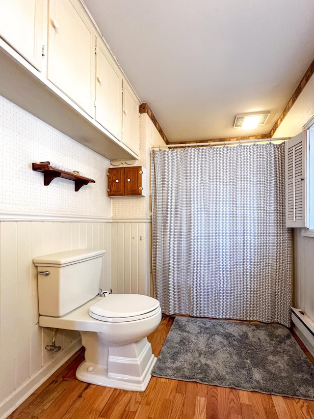 bathroom with hardwood / wood-style flooring, toilet, and a shower with shower curtain