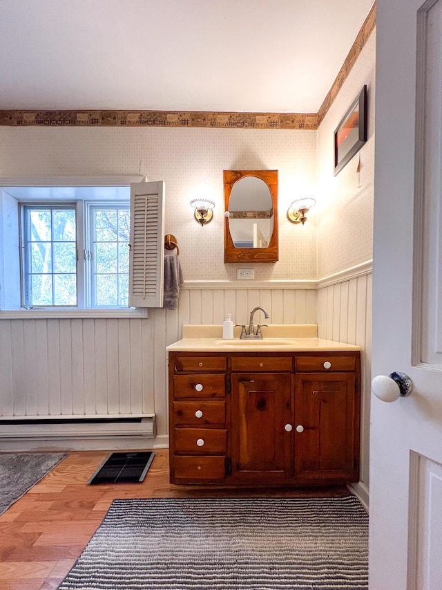 bathroom with vanity, wood-type flooring, and a baseboard heating unit