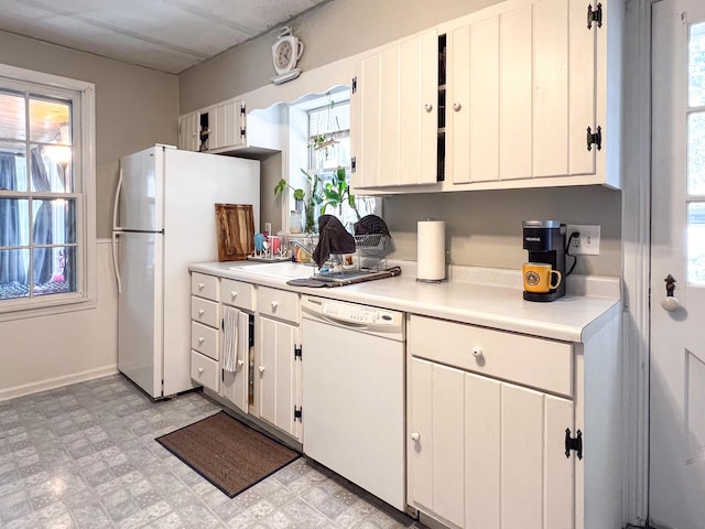 kitchen with white appliances, white cabinetry, and plenty of natural light