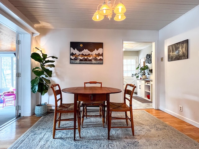 dining area with crown molding, a notable chandelier, and wood-type flooring