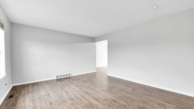 spare room featuring wood-type flooring