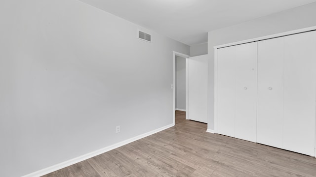 unfurnished bedroom featuring light wood-type flooring and a closet