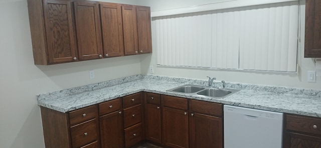 kitchen with light stone counters, sink, dark brown cabinets, and dishwasher