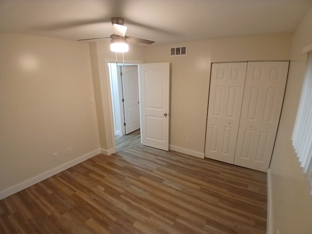 unfurnished bedroom featuring hardwood / wood-style flooring, ceiling fan, and a closet