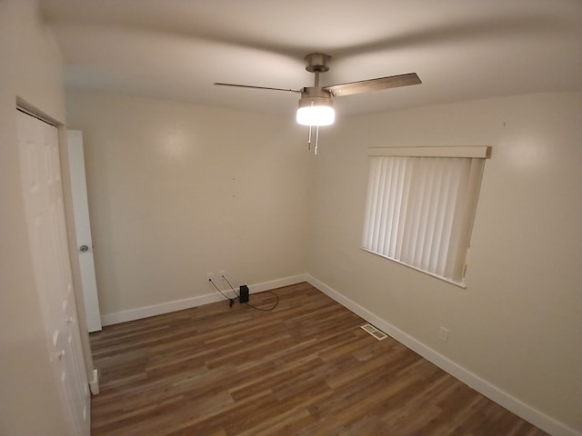 spare room featuring dark wood-type flooring and ceiling fan