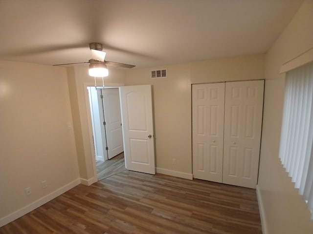 unfurnished bedroom with hardwood / wood-style floors, a closet, and ceiling fan