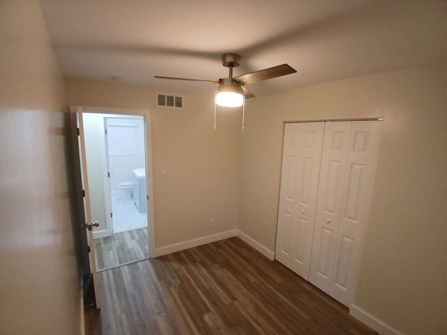 unfurnished bedroom with ceiling fan, dark hardwood / wood-style flooring, and a closet