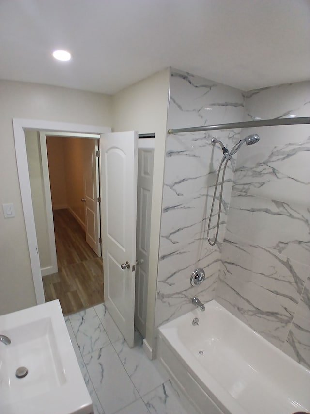 bathroom with tiled shower / bath combo and sink