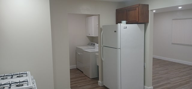 laundry room with hardwood / wood-style flooring, cabinets, and independent washer and dryer