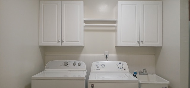 washroom with sink, cabinets, and washer and dryer