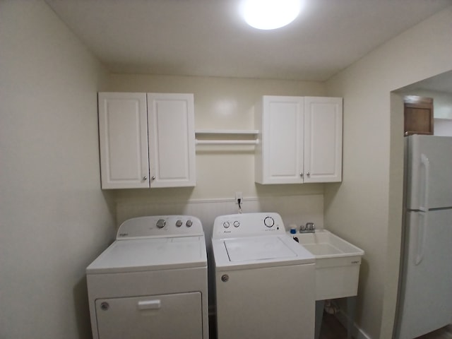 laundry room with sink, washer and clothes dryer, and cabinets