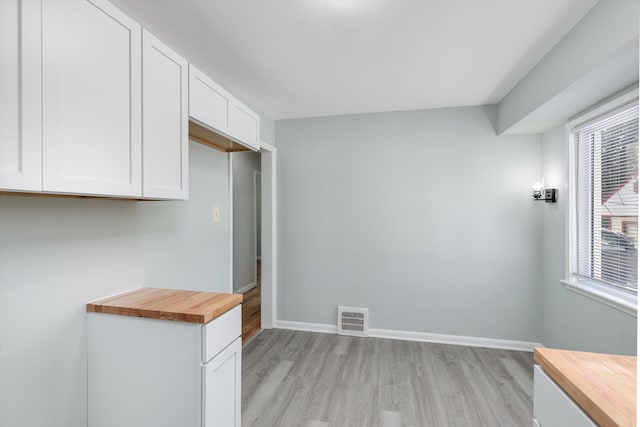 kitchen featuring wood counters, light wood-type flooring, and white cabinets