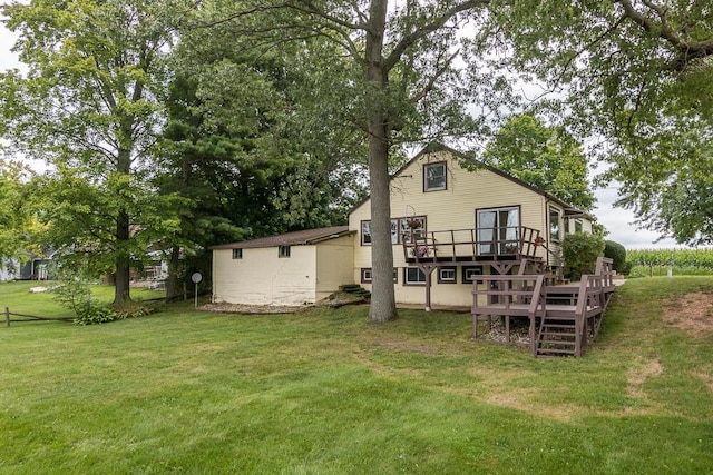 back of house featuring a deck and a lawn