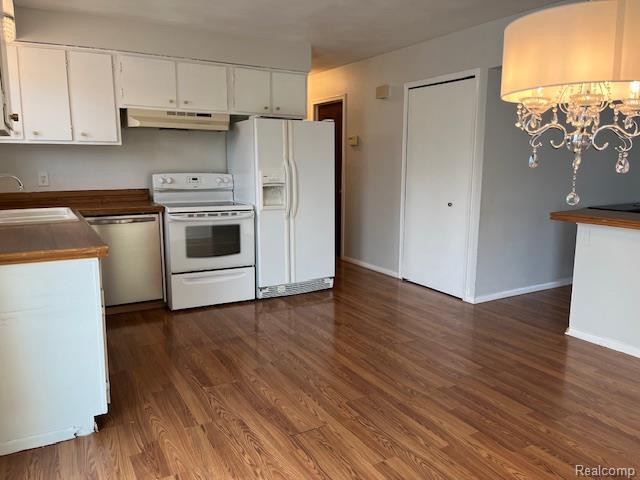 392 Hillcrest Dr, Saline, MI 48176 - kitchen featuring white appliances, under cabinet range hood, dark wood-style floors, and a chandelier