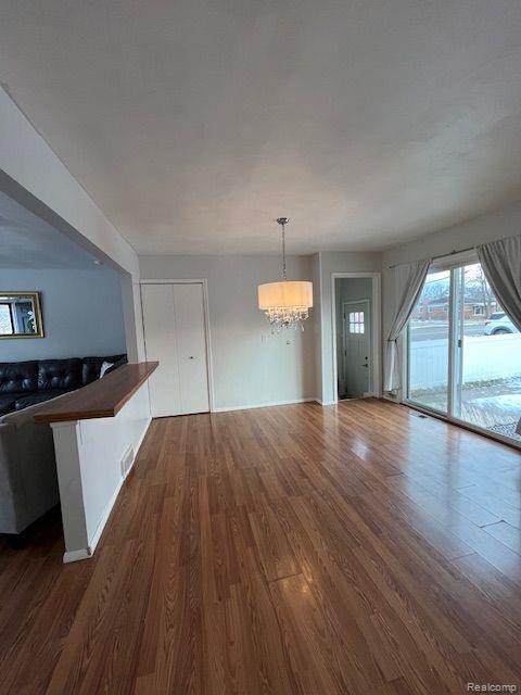392 Hillcrest Dr, Saline, MI 48176 - unfurnished dining area featuring a chandelier and dark wood finished floors