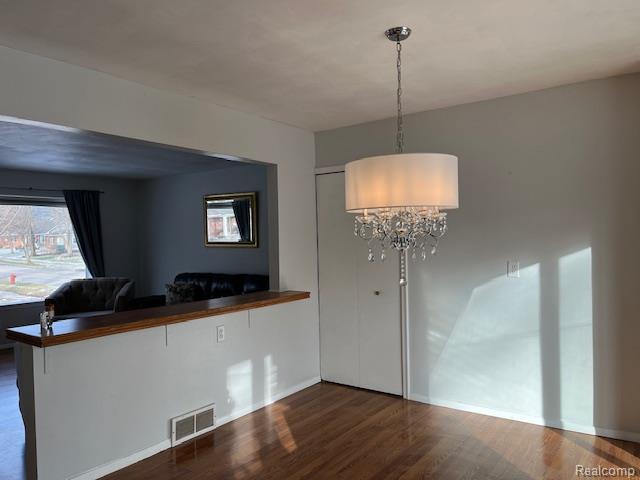 392 Hillcrest Dr, Saline, MI 48176 - unfurnished dining area featuring a chandelier and wood finished floors