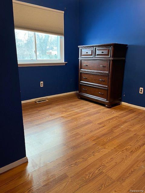 392 Hillcrest Dr, Saline, MI 48176 - unfurnished bedroom with light wood-style floors and baseboards