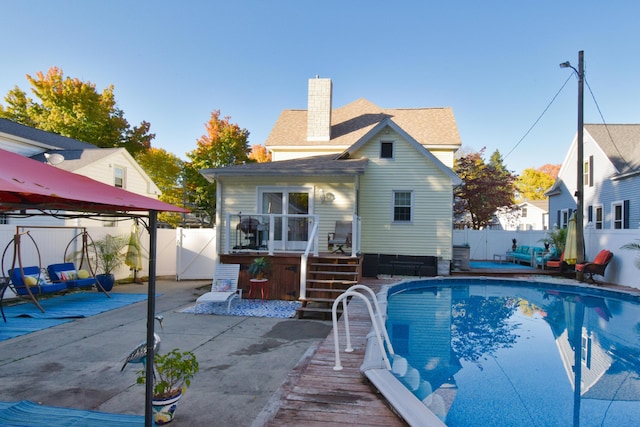 rear view of house with a swimming pool side deck and a patio area