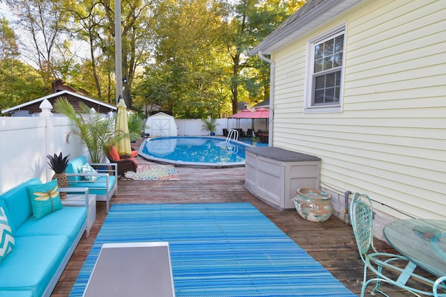 wooden terrace with a gazebo, a storage unit, outdoor lounge area, and a fenced in pool