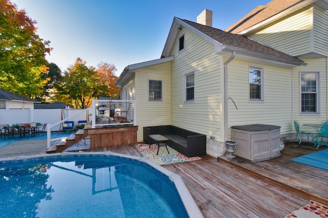 back of property with a swimming pool side deck and an outdoor living space