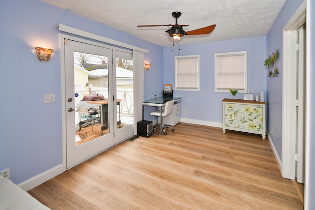 home office featuring ceiling fan, a textured ceiling, and light wood-type flooring