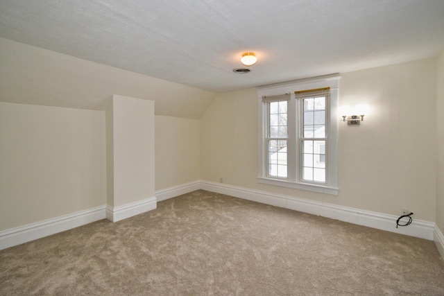 additional living space featuring lofted ceiling and carpet floors