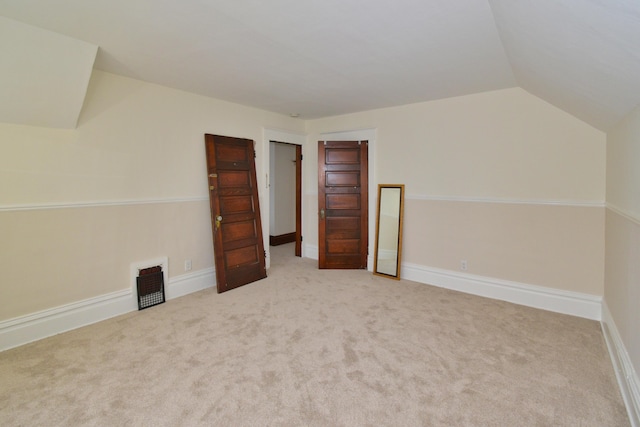 additional living space featuring vaulted ceiling and carpet flooring