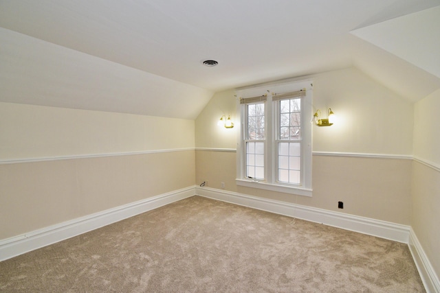 bonus room featuring lofted ceiling and light colored carpet