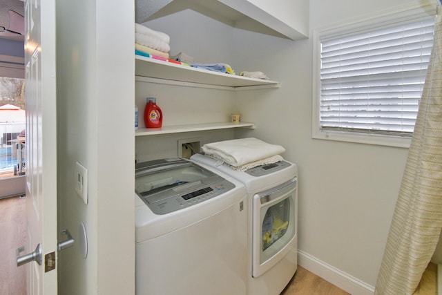 laundry area featuring light hardwood / wood-style floors and washing machine and dryer