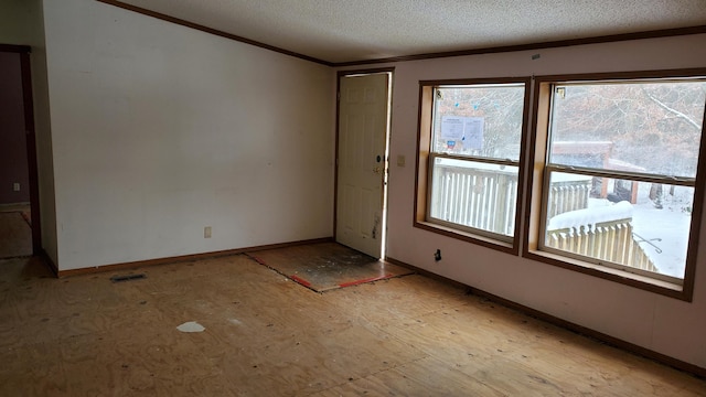 spare room with ornamental molding and a textured ceiling