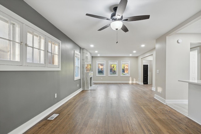 unfurnished living room with ceiling fan and dark hardwood / wood-style flooring