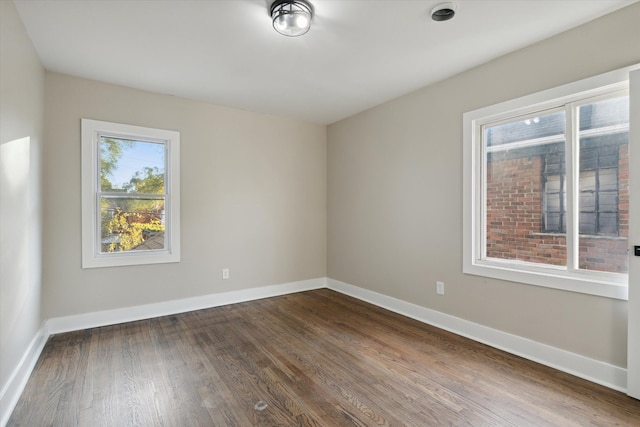 unfurnished room with dark hardwood / wood-style flooring