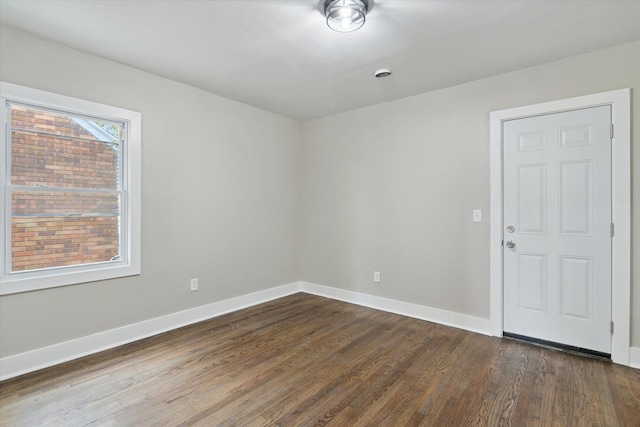 unfurnished room with dark hardwood / wood-style flooring