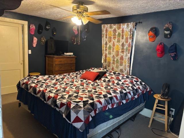 carpeted bedroom with ceiling fan and a textured ceiling