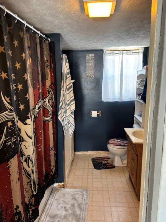 bathroom featuring vanity, toilet, and a textured ceiling