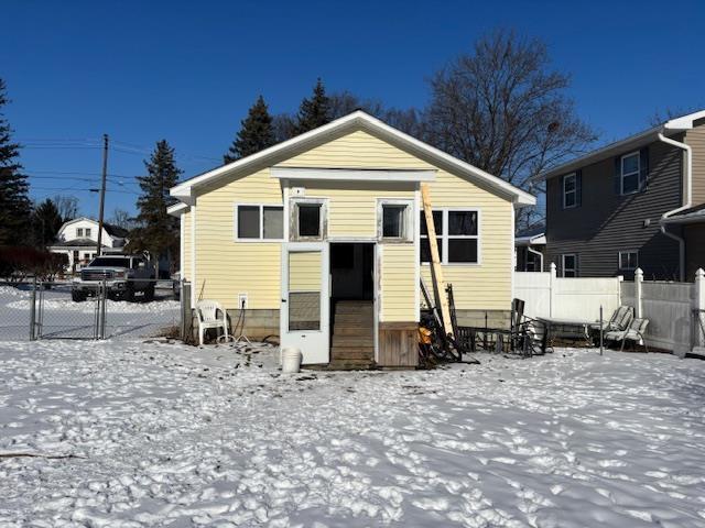 view of snow covered rear of property