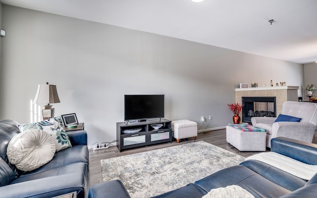 living room featuring a tile fireplace and wood-type flooring