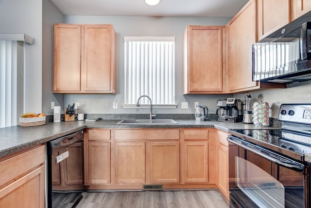 kitchen with light hardwood / wood-style floors, light brown cabinetry, sink, and black appliances