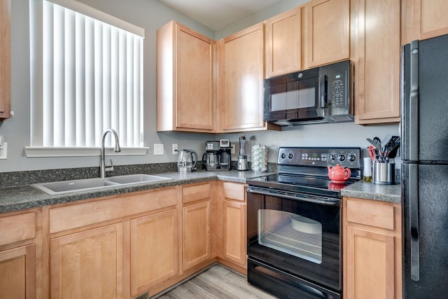 kitchen with sink, light wood-type flooring, black appliances, and light brown cabinets