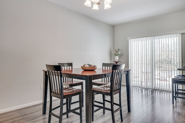 dining space with wood-type flooring and a notable chandelier