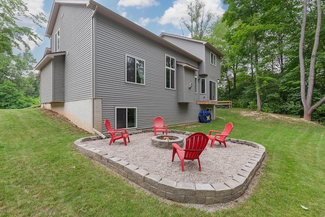 rear view of property featuring a lawn, a patio area, and an outdoor fire pit