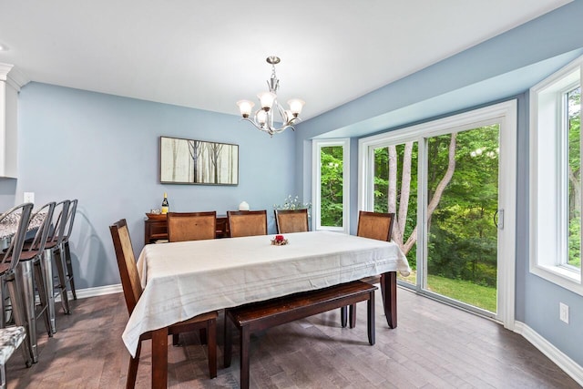 dining space featuring a chandelier, a wealth of natural light, and dark hardwood / wood-style flooring