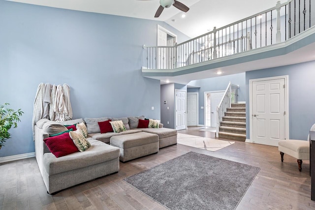 living room with wood-type flooring, high vaulted ceiling, and ceiling fan