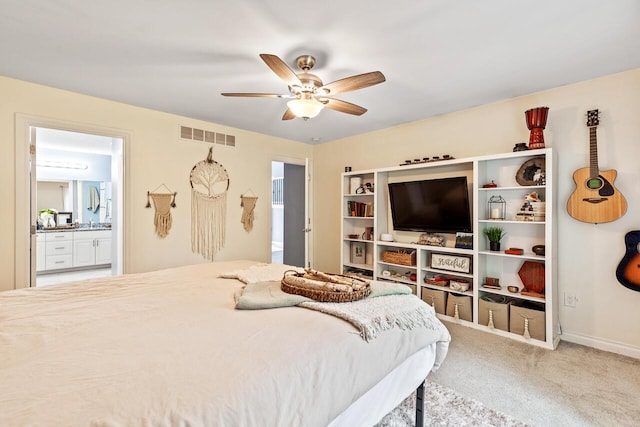 bedroom with ceiling fan, connected bathroom, and carpet floors