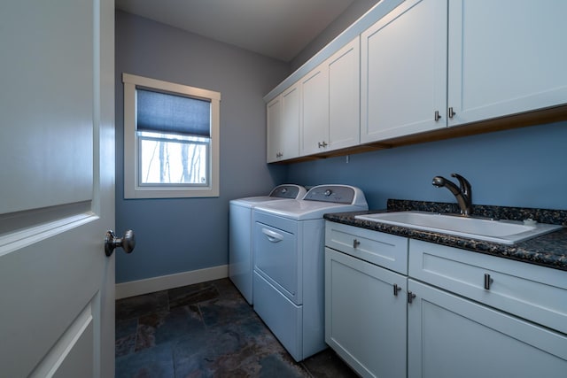 clothes washing area with cabinets, washer and clothes dryer, and sink