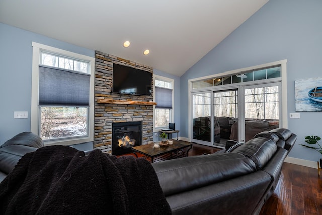 living room featuring dark wood-type flooring, a fireplace, and high vaulted ceiling