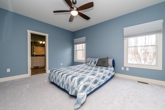 carpeted bedroom featuring ceiling fan and ensuite bath